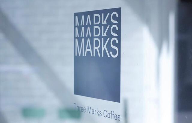 Logotipo de Three Marks Coffee en una ventana