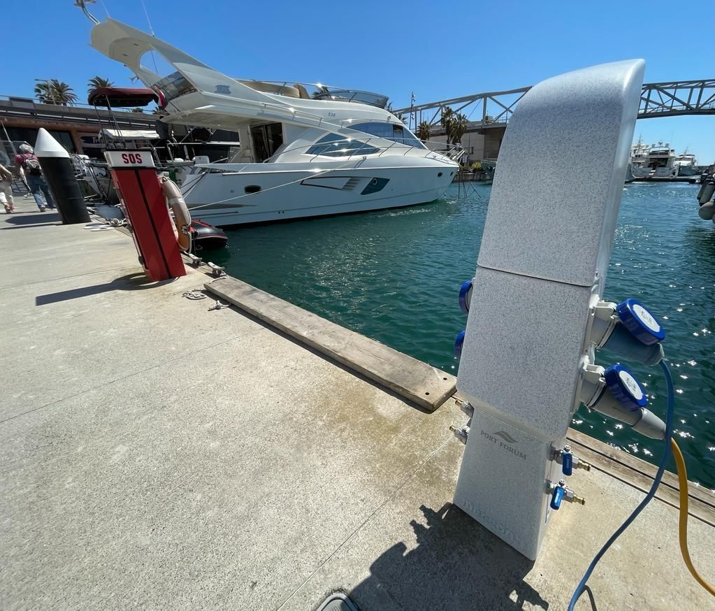 Puerto con yate y torretas de servicio.