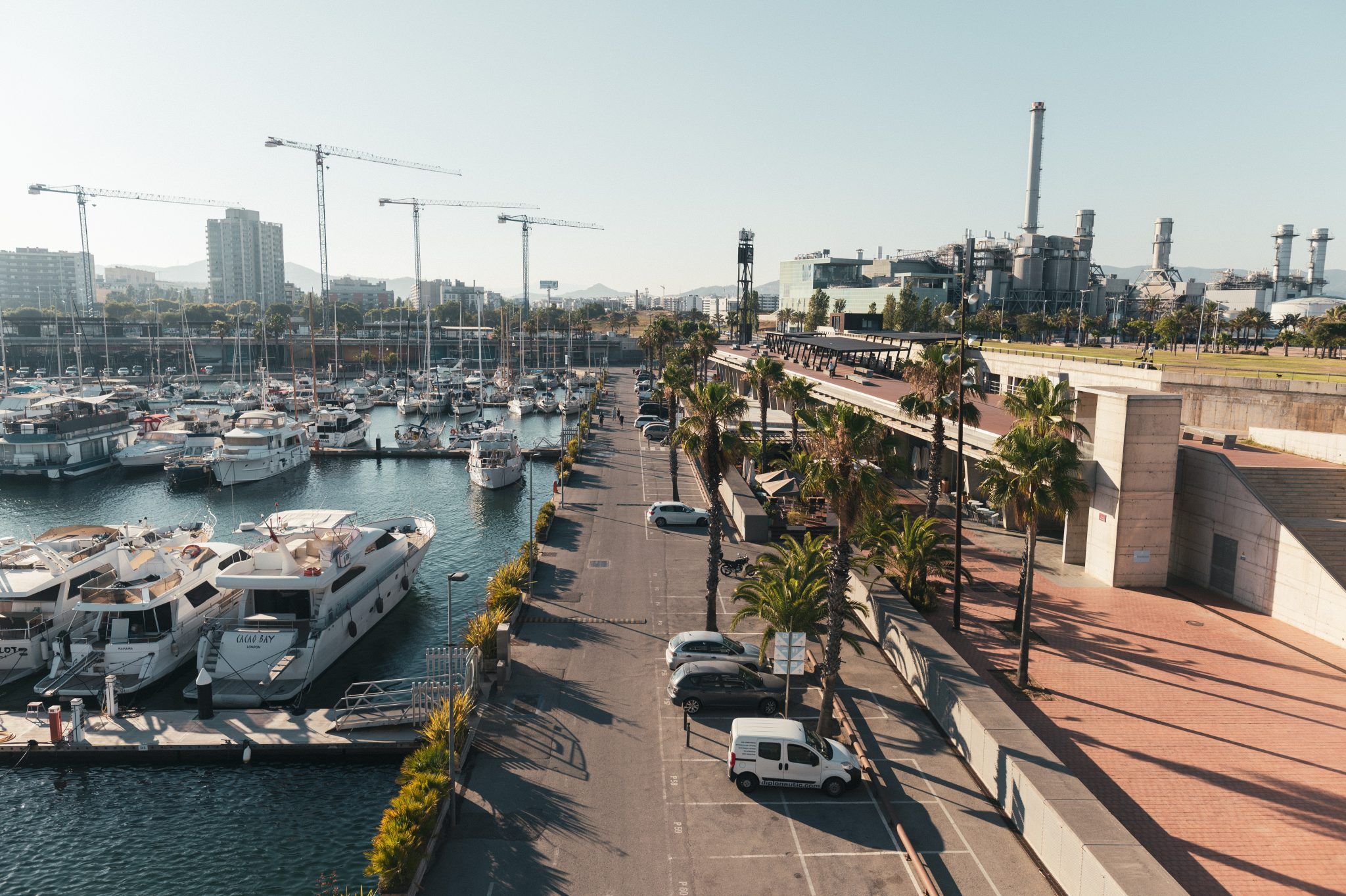Puerto de Barcelona con yates y zona industrial.