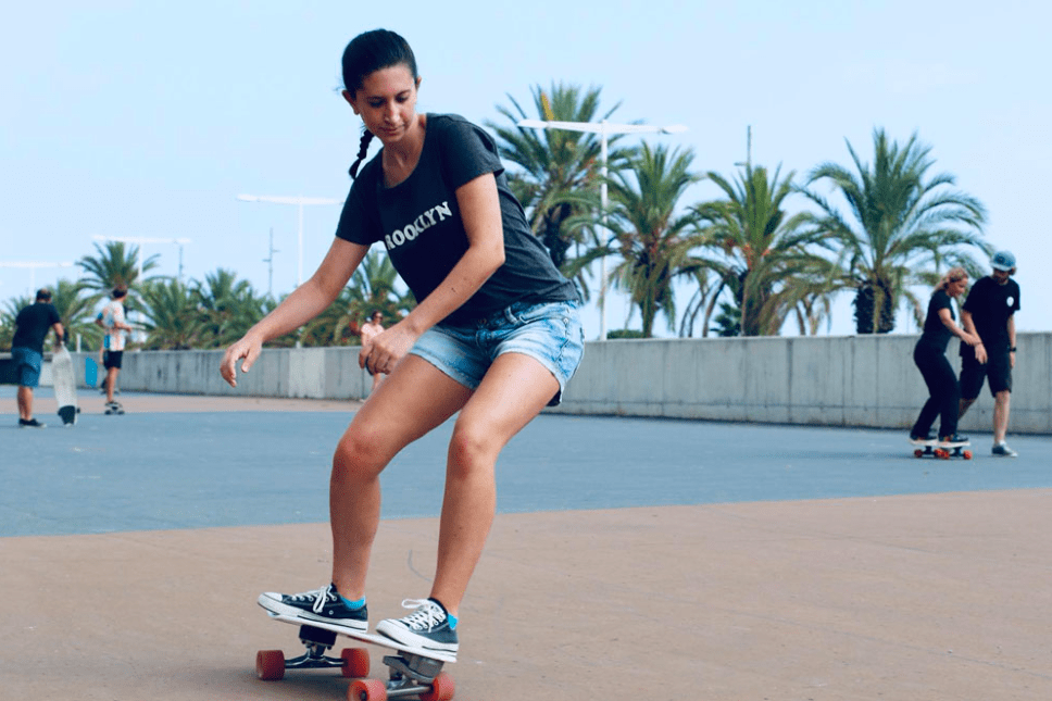 Mujer patinando en monopatín en el puerto.