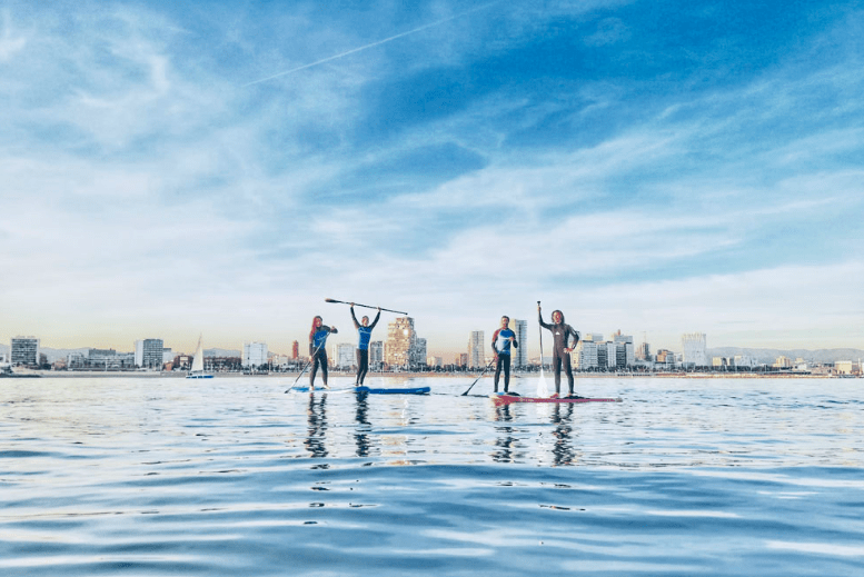 Personas practicando paddle surf en el puerto
