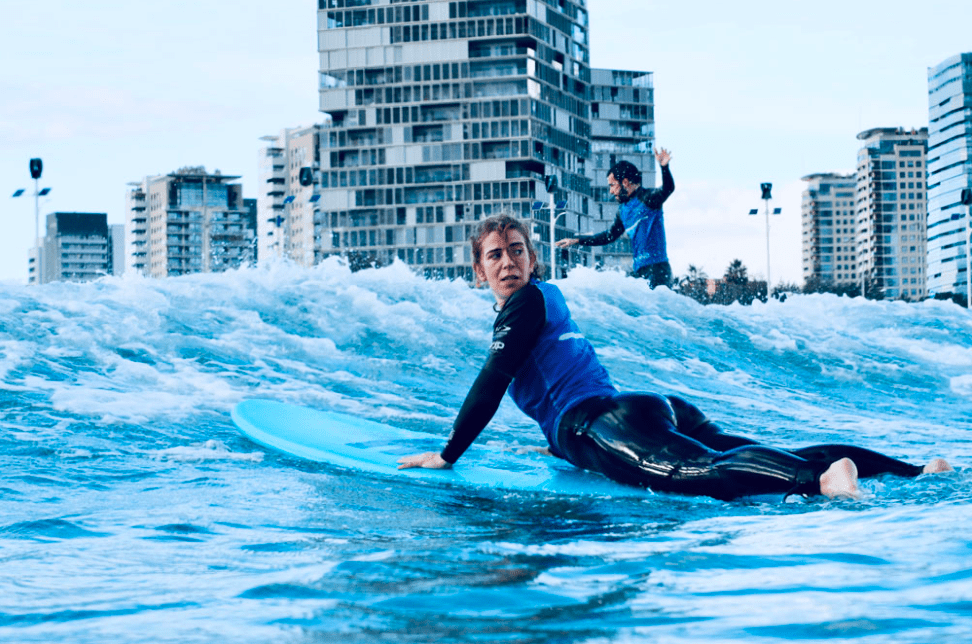 Mujer practicando surf indoor en ciudad