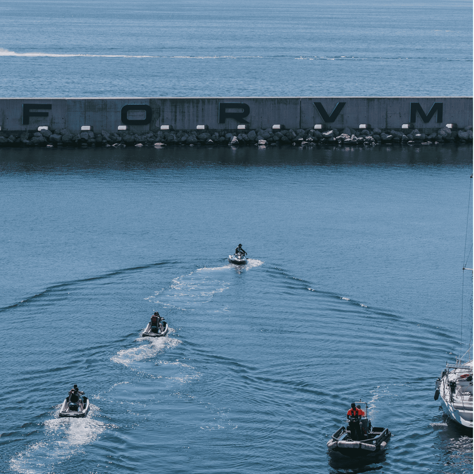 Motos de agua en el mar con muro "FORVM