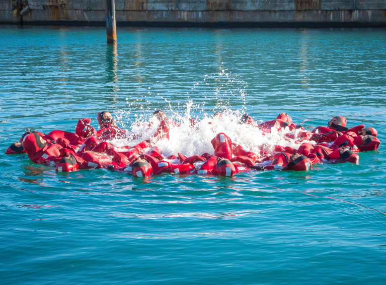Grupo de personas en el agua con trajes rojos.