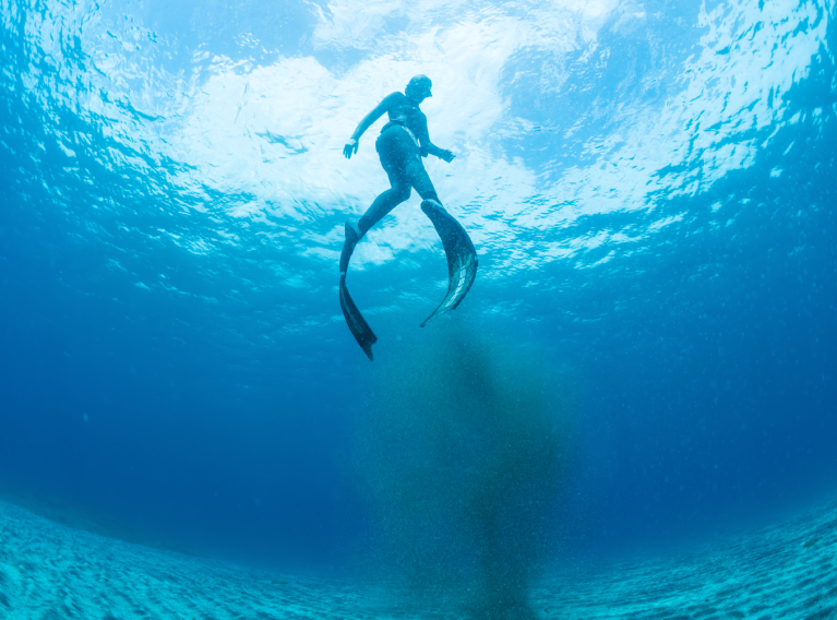 Buceadora en apnea bajo el agua.