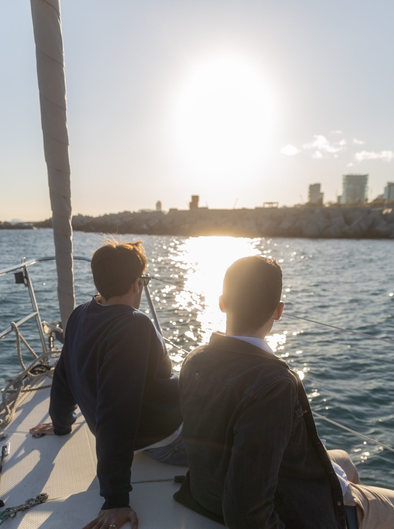 Dos personas en velero al atardecer.