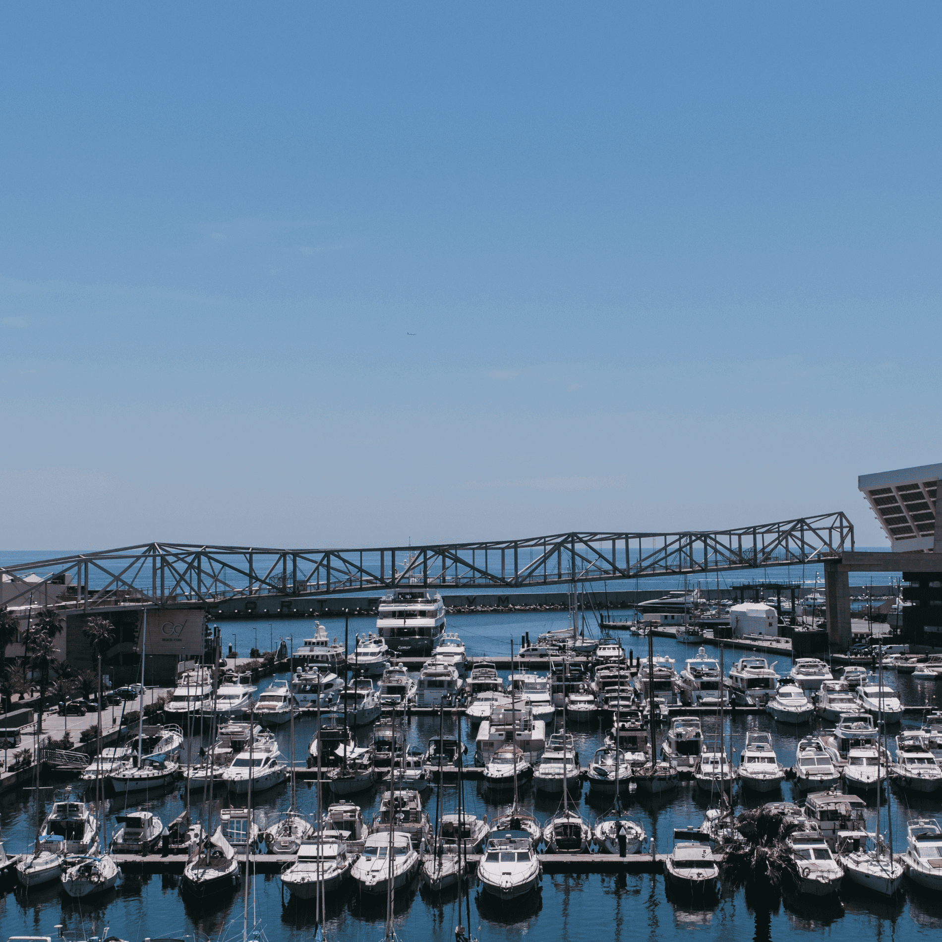 Marina llena de barcos bajo un puente.