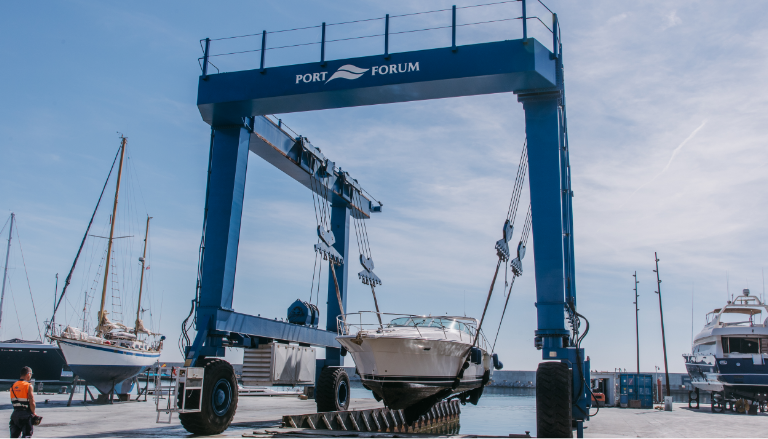 Grúa pórtico elevando un barco en el puerto