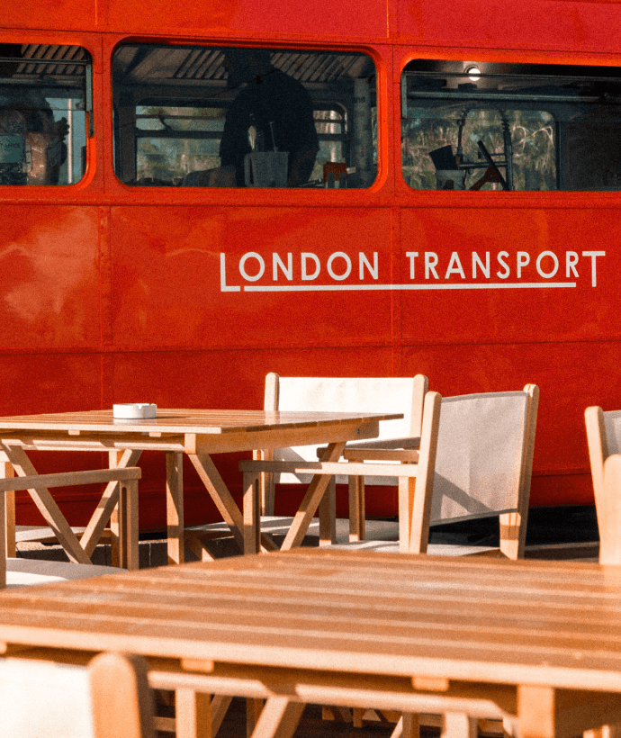 Autobús rojo London Transport con mesas exteriores