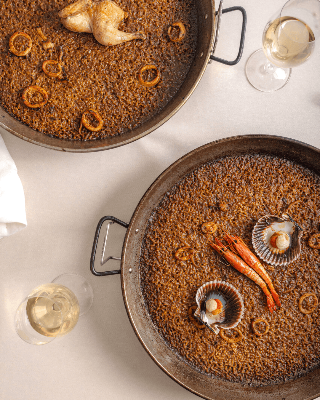Paellas de marisco y pollo con vino blanco.