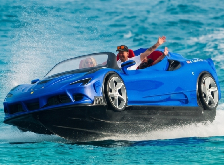 Pareja en coche anfibio azul en el mar